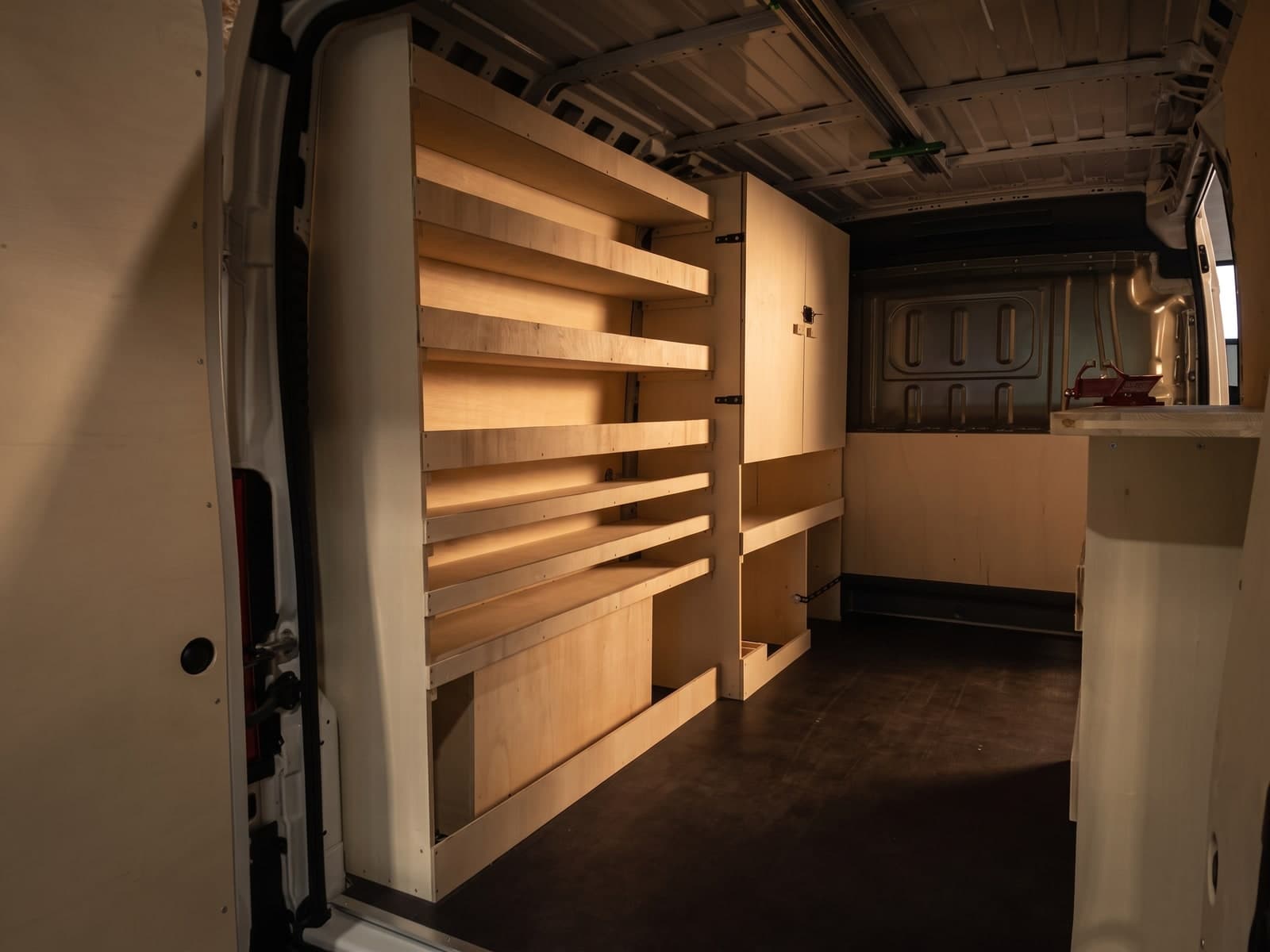 Grand fourgon aménagé en atelier roulant : rayonnage bouleau, armoire et établi avec étau